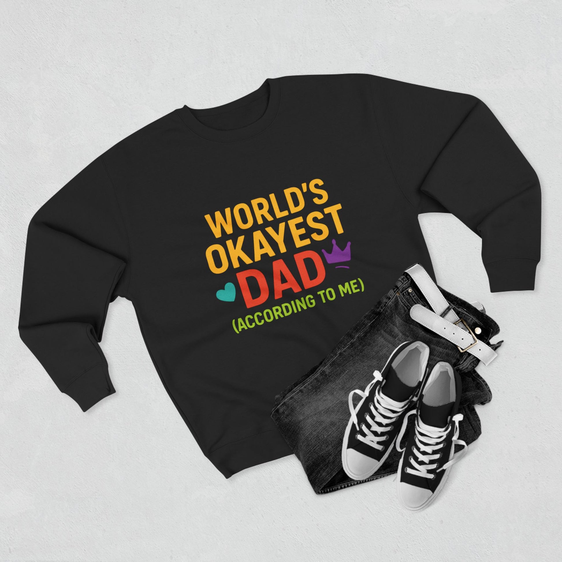 Black sweatshirt with colorful text 'World's Okayest Dad' on a light gray background