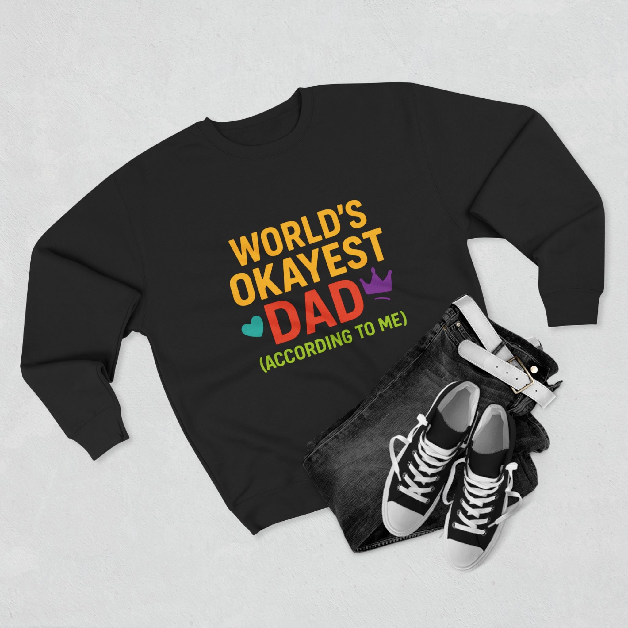Black sweatshirt with colorful text 'World's Okayest Dad' on a light gray background